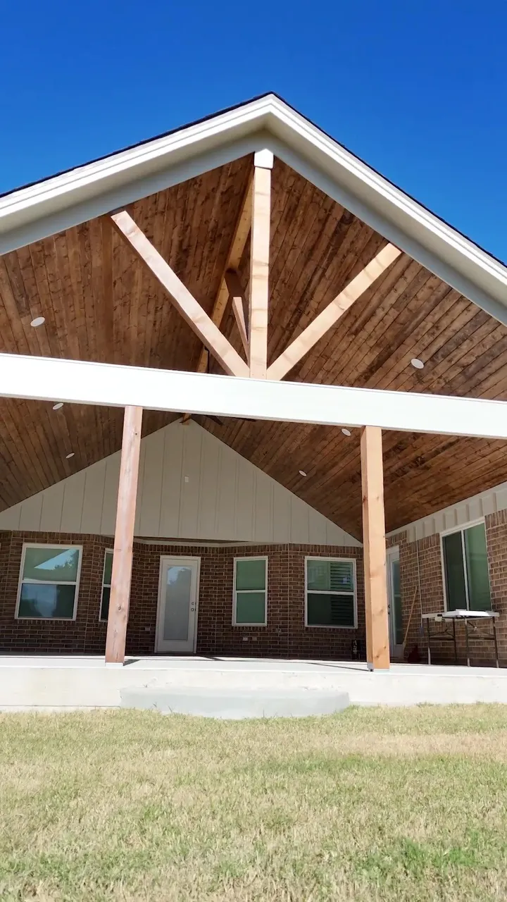 Finished gable patio cover seen front on, with a cedar truss and white fascia