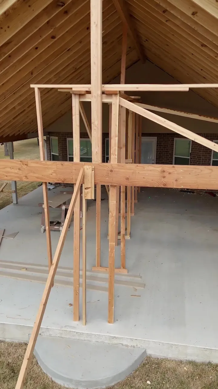 Patio framing with temporary bracing on the new slab and the cedar ceiling above