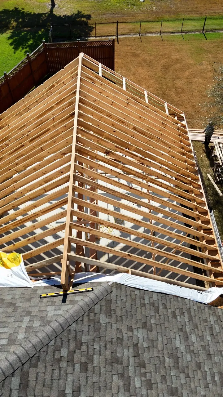 Top down on freshly framed patio rafters tying into the roof