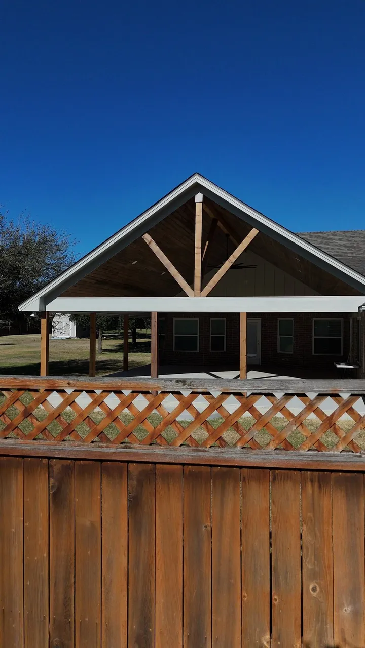 Finished gable patio cover seen over the cedar privacy fence