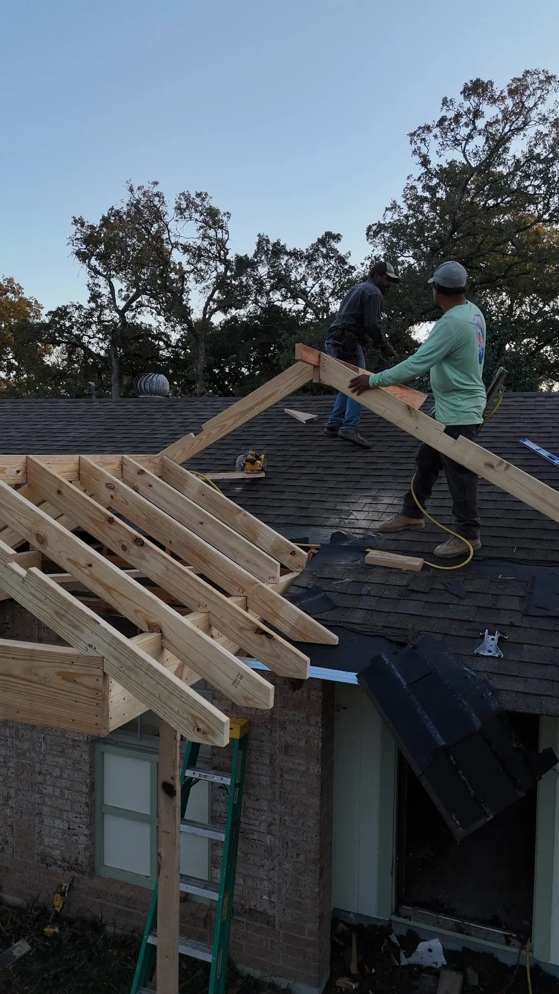 New addition rafters set over the existing roof at golden hour