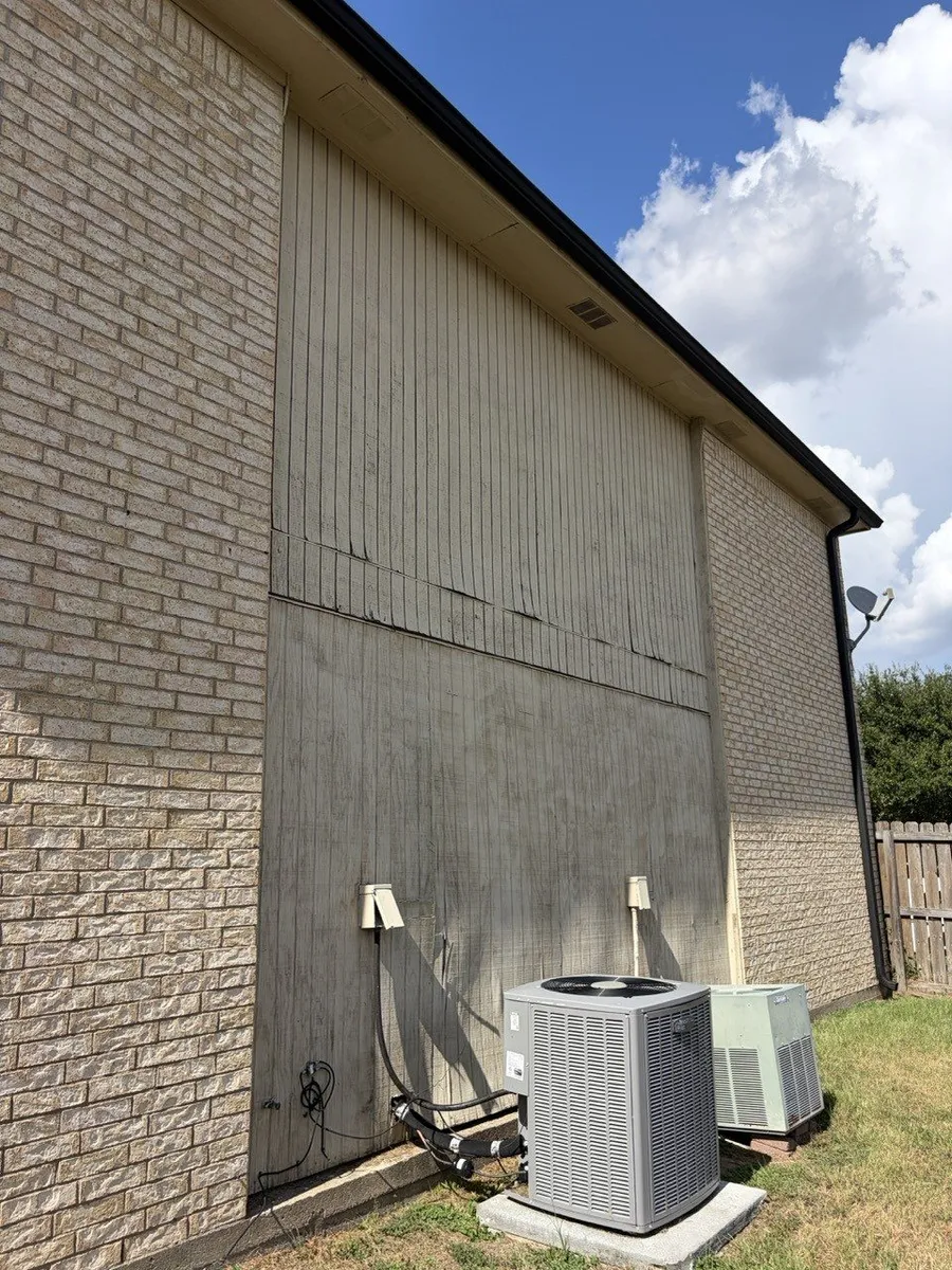 Before the work: a tall gable wall of failing siding